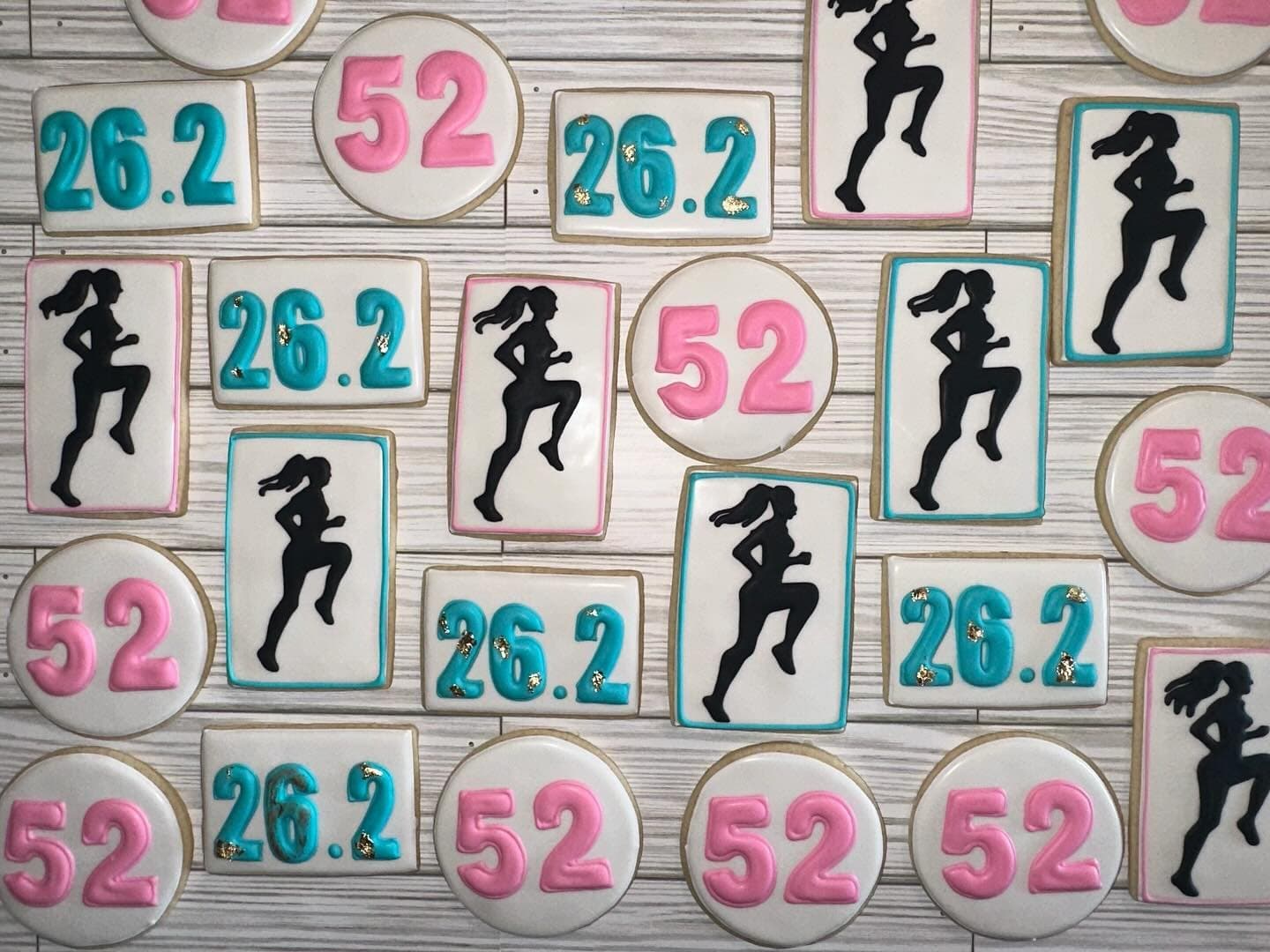 Pink and white cookies with runner silhouettes, 26.2 plaques and birthday numbers